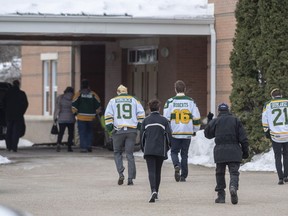 Community members wearing jerseys enter St. Augustine Church prior to a memorial service for Brody Hinz, the Humboldt Broncos statistics compiler, who one of 16 people killed in a bus crash on April 6th 2018, in Humboldt, Sask., Saturday, April 14, 2018.