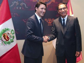 In this handout photo provided by the Peruvian government, Peru's President Martin Vizcarra, right, shakes hands with Canada's Prime Minister Justin Trudeau, at the government palace in Lima, Peru, Friday, April 13, 2018. Trudeau is in Lima to attend the Americas Summit which begins today.