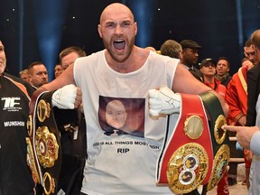 FILE - In this Nov. 29, 2015 file photo, Britain's new world champion Tyson Fury, celebrates with the WBA, IBF, WBO and IBO belts after winning the world heavyweight title fight against Ukraine's Wladimir Klitschko in Duesseldorf, western Germany. Tyson Fury is back in heavyweight boxing after nearly 2 1/2 years away. He credits some straight talk from fellow heavyweight boxer Deontay Wilder for getting him to return to the ring. Fury's comeback fight is in Manchester, England, on June 9, 2018.