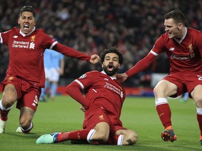 Liverpool's Mohamed Salah, center, celebrates with teammates after scoring his side's first goal of the game during the Champions League quarter final, first leg soccer match between Liverpool and Manchester City at Anfield, Liverpool, England, Wednesday, April 4, 2018.