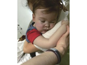 In this April 23, 2018 handout photo provided by Alfies Army Official, brain-damaged toddler Alfie Evans cuddles his mother Kate James at Alder Hey Hospital, Liverpool, England. The father of a terminally ill British toddler said the child is surviving after being taken off life support, surprising doctors who had argued he should be allowed to die. Tom Evans said his 23-month-old son, Alfie, survived for six hours with no assistance, and that doctors are now providing oxygen and hydration.