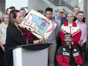 Former Olympic bobsledder Helen Upperton speaks and shows a poster that she made as a child for the 1988 Calgary winter games as athletes hold a press conference and panel discussion to encourage the city of Calgary to continue a Winter Olympic bid for 2026 in Calgary, Alta. on Friday, Apr. 13, 2018.