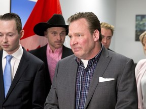 Family members and MP Michael Cooper, left, look on as Scott Hamilton, centre, holds back tears as he talks about murder trial delays for victims Sara Baillie and her daughter Taliyah Marsman at a press conference in Calgary, Alta. on Tuesday, March 3, 2018. Hamilton is Sara Baillie's uncle.