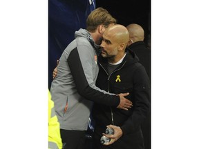Liverpool manager Juergen Klopp, left, speaks with Manchester City manager Pep Guardiola before the Champions League quarterfinal second leg soccer match between Manchester City and Liverpool at Etihad stadium in Manchester, England, Tuesday, April 10, 2018.