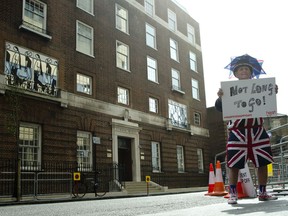 FILE - In this Friday, April 24, 2015 file photo, Terry Hutt poses for the media with a sign that reads 'Not Long to Go' as he waits with other royal fans, outside the Lindo wing at St Mary's Hospital in London.  Kensington Palace says Prince William's wife, the Duchess of Cambridge has entered a London hospital to give birth to the couple's third child. The former Kate Middleton traveled by car on Monday, April 23, 2018 to the private Lindo Wing of St. Mary's Hospital in central London. The palace says she was in "the early stages of labor."