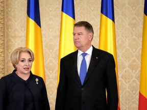 FILE - In this Monday, Jan. 29, 2018 file photo, Romanian Prime Minister Viorica Dancila, left, stands next to Romania's President Klaus Iohannis after the swearing in of her cabinet, in Bucharest, Romania. Romania's President Klaus Iohannis on Friday April 27, 2018, has asked the Prime Minister Viorica Dancila to resign, saying she is unfit for the job.