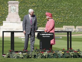 Britain's Queen Elizabeth II talks to John Spurling, Chairman of London Marathon Events, before pressing a button to start the London Marathon from Windsor Castle, Windsor, England, Sunday April 22, 2018, which is relayed to big screens at the start of the Marathon setting off 40,000 runners.