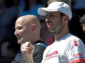 FILE - In this Tuesday, Jan. 16, 2018 file photo, Serbia's Novak Djokovic coaches Radek Stepanek, right, and Andre Agassi, left, watch Djokovic play United States' Donald Young in their first round match at the Australian Open tennis championships in Melbourne, Australia. Novak Djokovic announced on Wednesday April 4, 2018, he has dismissed his coaching team Andre Agassi and Radek Stepanek. It comes after two straight first round defeats at Indian Wells and the Miami Open following a recovery from a long term elbow injury.