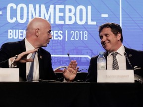 FILE - In this Thursday, April 12, 2018 file photo, FIFA President Gianni Infantino, left, talks with Alejandro Dominguez, right, president of the South American Football Confederation, CONMEBOL, during their annual conference in Buenos Aires, Argentina. FIFA hosted talks Monday April 30, 2018, with football's six continental governing bodies about a $25 billion offer to run two international competitions, seeking agreement before the World Cup kicks off in June.