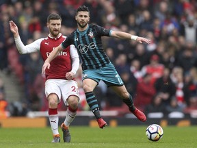 Arsenal's Shkodran Mustafi, left, and Southampton's Shane Long in action during their English Premier League soccer match at the Emirates Stadium in London, Sunday April 8, 2018.