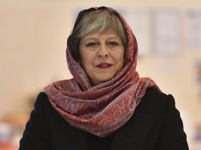 Britain's Prime Minister Theresa May during her visit to the Guru Nanak Sikh Gurdwara, in Walsall, England, Wednesday April 11, 2018.  May has summoned her Cabinet back from vacation on Thursday April 12, 2018, to discuss military action against Syria over an alleged chemical weapons attack.