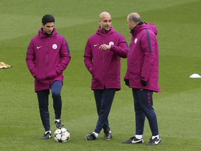 Manchester City manager Pep Guardiola, centre, speaks to his coaching staff during a training session at Anfield in Liverpool, England, Tuesday April 3, 2018. Manchester City and Liverpool will play the first leg of their Champions League soccer quarter final on Wednesday.