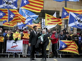 Backdropped by supporters former Catalan Minister Professor Clara Ponsati, who is facing extradition to Spain, stands outside Edinburgh Sheriff Court with her lawyer Aamer Anwar, left, after an extradition hearing, Thursday April 12, 2018. Former Catalan education minister Professor Clara Ponsati returned to court Thursday facing an extradition hearing on charges of violent rebellion and misappropriation of public funds over her role in Catalonia's controversial independence referendum last year.