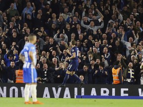 Tottenham Hotspur's Harry Kane, centre,  celebrates scoring his side's first goal of the game,  during the English Premier League soccer match between Brighton and Tottenham Hotspur, at the AMEX Stadium, in Brighton, England, Tuesday April 17, 2018.