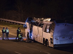 A bus that was carrying teenage passengers sits on the side of a highway after it hit an overpass on the Southern State Parkway in Lakeview, N.Y., Monday, April 9, 2018.
