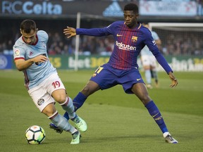 RC Celta's Jonny Otto, left, challenges for the ball with Barcelona's Ousmane Dembele during a Spanish La Liga soccer match between RC Celta and Barcelona at the Balaidos stadium in Vigo, Spain, Tuesday April 17, 2018.