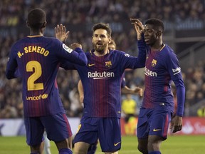 Barcelona's Nelson Semedo, left, Massi, center, and Ousmane Dembele celebrate after a second goal was scored, during a Spanish La Liga soccer match between RC Celta and Barcelona at the Balaidos stadium in Vigo, Spain, Tuesday April 17, 2018.
