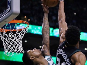 Boston Celtics guard Marcus Smart, left, blocks a shot by Milwaukee Bucks forward Giannis Antetokounmpo during the first quarter of Game 5 of an NBA basketball first-round playoff series in Boston, Tuesday, April 24, 2018.