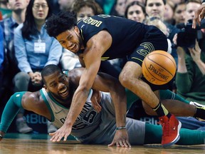 Boston Celtics' Greg Monroe (55) and Atlanta Hawks' Tyler Dorsey, top, battle for the ball during the second quarter of an NBA basketball game in Boston, Sunday, April 8, 2018.