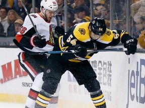 Ottawa Senators' Magnus Paajarvi (56), of Sweden, and Boston Bruins' Adam McQuaid (54) battle for the puck during the first period of an NHL hockey game in Boston, Saturday, April 7, 2018.