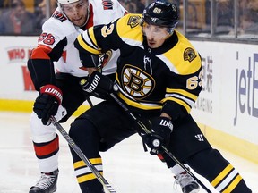 Ottawa Senators' Magnus Paajarvi (56), of Sweden, battles Boston Bruins' Brad Marchand (63) for the puck during the second period of an NHL hockey game in Boston, Saturday, April 7, 2018.
