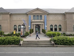 FILE - In this July 12, 2017. file photo, a pedestrian walks past the Berkshire Museum in Pittsfield, Mass. A judge has approved a plan for a cash-strapped Massachusetts museum to sell dozens of pieces of art, including works by Norman Rockwell. The decision Thursday, April 5, 2018, from Justice David Lowy of Massachusetts' highest court clears the way for the contentious sale of up to 40 pieces of artwork at the Berkshire Museum.