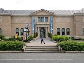 FILE - In this July 12, 2017 file photo, a pedestrian passes the Berkshire Museum in Pittsfield, Mass. The Massachusetts museum that won a legal battle over its plan to sell dozens of works of art announced Tuesday, April 10, 2018, that 13 of those pieces, including one by Norman Rockwell, will be auctioned next month. Rockwell's "Blacksmith's Boy-Heel and Toe" is among the pieces for sale by Sotheby's in May, the Berkshire Museum announced. Works by William Bouguereau, Alexander Calder and John La Farge also are going on the auction block.