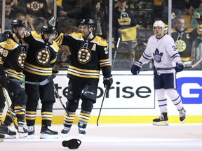 As Toronto Maple Leafs' Auston Matthews, right, skates away, David Pastrnak, left, is congratulated byBruins teammates Torey Krug (47), Brad Marchand and Patrice Bergeron after he scored his third goal of the game during Game 2 of their first-round playoff series in Boston on Saturday night.