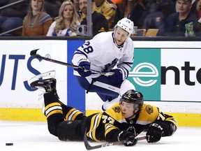Toronto Maple Leafs' Connor Brown (28) and Boston Bruins' Charlie McAvoy eye the puck during the third period of Boston's win in Game 2 of an NHL hockey first-round playoff series in Boston, Saturday, April 14, 2018.