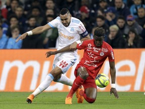 Marseille's Dimitri Payet, left, challenges for the ball with Montpellier's Nordi Mukiele, during the League One soccer match between Marseille and Montpellier at the Velodrome stadium, in Marseille, southern France, Sunday, April 8, 2018.