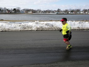 In this Thursday, March 15, 2018, photo, marathon runner John Young, of Salem, Mass., makes his way along a training route in Salem. Young was born with dwarfism, but that hasn't stopped him from conquering multiple marathons and triathlons. While most marathoners take about 35,000 steps to reach the finish line, Young uses about 80,000.
