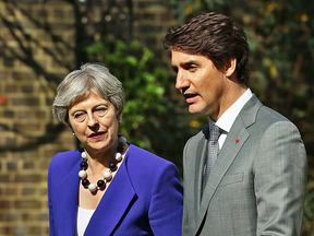 Britain's Prime Minister Theresa May speaks with Prime Minister Justin Trudeau in the garden at 10 Downing Street on April 18, 2018 in London.