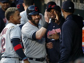 Cleveland Indians' Jason Kipnis, center, high-fives teammates in the dugout after scoring when Edwin Encarnacion was hit by a pitch with the bases loaded in the first inning of a baseball game against the Baltimore Orioles, Friday, April 20, 2018, in Baltimore.
