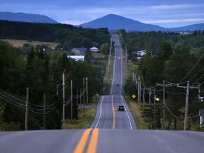 FILE - In this Aug. 6, 2017, file photo, motorists travel on Rte. 11 south of Patten, Maine, near the Katahdin Woods and Waters National Monument. Road signs directing motorists to the national monument are going to be installed now that Republican Gov. Paul LePage has relented in his opposition to the signs on Interstate 95 and state roads leading to the Mount Katahdin region. The Maine Department of Transportation will allow signs to be manufactured and installed now that Interior Secretary Ryan Zinke has recommended keeping the monument and a renewed request has been submitted by the superintendent for the federal land, the governor's office said.