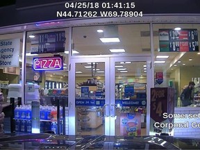 This dash cam photo released by the Maine State Police shows John Williams of Madison, Maine, robbing a convenience store Wednesday morning, April 25, 2018, in Norridgewock, Maine. Maine authorities are searching for Williams, who they say fatally shot a sheriff's deputy, stole his cruiser and robbed the Cumberland Farms store. (Maine State Police via AP)