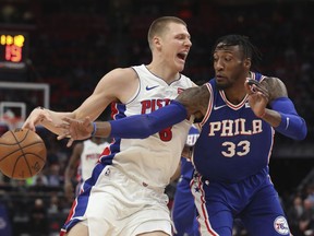 Philadelphia 76ers forward Robert Covington (33) reaches for the ball on Detroit Pistons forward Henry Ellenson (8) during the first half of an NBA basketball game Wednesday, April 4, 2018, in Detroit.