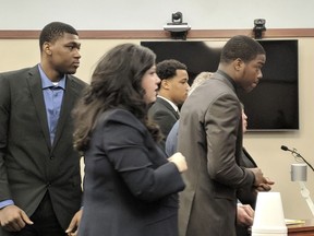 From left, former Michigan State football players Josh King, Demetric Vance and Donnie Corley appear with their attorneys in Ingham County Circuit Court, Wednesday April 4, 2018 in East Lansing, Migh.  The three former football players accused in the 2017 sexual assault of a woman in an apartment bathroom have pleaded guilty to reduced charges.