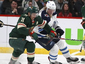 Minnesota Wild left wing Zach Parise (11) battles with Winnipeg Jets right wing Patrik Laine (29) in the first period of Game 3 of an NHL first-round hockey playoff series Sunday, April 15, 2018, in St. Paul, Minn. The Wild won the game 6-2 but trail the Jets 2-1 in the series.