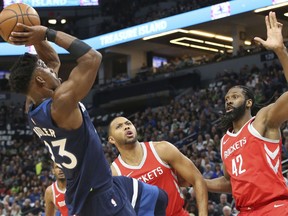 Minnesota Timberwolves' Jimmy Butler, left, shoots as Houston Rockets' Eric Gordon, center, and Nene, of Brazil, watch in the first half during Game 3 of an NBA basketball first-round playoff series Saturday, April 21, 2018, in Minneapolis.