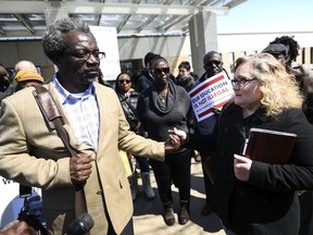 Lori Nixon held the hand of Augsburg Professor Mzenga Wanyama as she expressed her support  outside of the Immigration and Customs Enforcement headquarters Thursday, April 5, 2018, in St. Paul, Minn., after it was announced that Wanyama was ordered to leave the country in 90 days. Nixon attends church with Wanyama at Woodbury Lutheran and is the godmother of his youngest son, a freshman at the University of Minnesota.