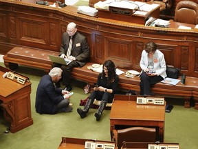 State Rep. Erin Maye Quade, of Apple Valley, second from right, holds a 24-hour sit-in on the Minnesota House floor for stronger gun laws, Tuesday, April 24, 2018, in St. Paul, Minn., joined by fellow Democratic-Farmer-Labor Party Reps. Raymond Dehn, Minneapolis, seated on floor; Peter Fischer, Maplewood, and JoAnn Ward, Woodbury.