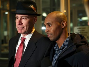 FILE - In this March 21, 2018, file photo, former Minneapolis Police Officer Mohamed Noor leaves the Hennepin County Public Safety Facility with his attorney, Thomas Plunkett, left, after posting bail in Minneapolis. Noor is charged with murder and manslaughter in the July death of Justine Ruszczyk Damond, who had called 911 to report a possible sexual assault behind her home. Police in Minneapolis announced Wednesday, April 4, 2018, new steps to make sure officers use body cameras in the wake of last summer's fatal shooting.