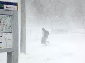 A traveler walks through the snow and ice to get to the Metro Government Center Plaza station as the snow picked up in downtown Minneapolis, Saturday, April 14, 2018.   The National Weather Service predicts 9 to 15 inches of snow across a large swath of southern Minnesota including the Twin Cities before it's all over.