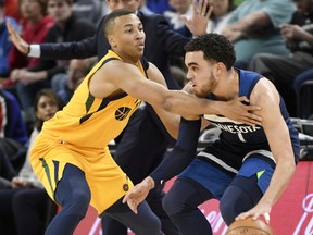 Utah Jazz's Dante Exum, left, defends against  Minnesota Timberwolves' Tyus Jones during the first quarter of an NBA basketball game Sunday, April 1, 2018, in Minneapolis.