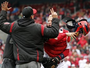 St. Louis Cardinals catcher Yadier Molina, right, throws off his mask as he argues with Arizona Diamondbacks manager Torey Lovullo during an altercation in the second inning of a baseball game Sunday, April 8, 2018, in St. Louis.