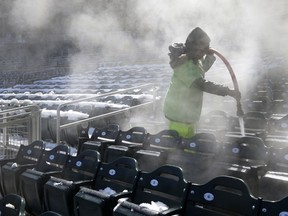 A worker is engulfed in steam while using hot water to melt snow in the stands and seats at Target Field in Minneapolis, Wednesday, April 4, 2018, following a snow storm, in preparation for Thursday's baseball home opener between the Minnesota Twins and the Seattle Mariners.