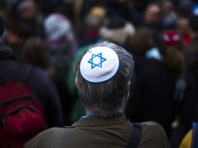 A man wears a Jewish skullcap, as he attends a demonstration against an anti-Semitic attack  in Berlin, Wednesday, April 25, 2018. Germans of various faiths donned Jewish skullcaps and took to the streets Wednesday in several cities to protest an anti-Semitic attack in Berlin and express fears about growing hatred of Jews in the country.