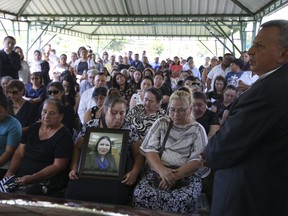 Demetrio Turcios, right, father of slain journalist Karla Turcios, addresses people attending Karla's funeral at the cemetery in San Salvador, El Salvador, Tuesday, April 17, 2018. The 33-year-old journalist, who worked for the magazine El Economista, owned by the La Prensa Grafica, was kidnapped on Saturday from her home and her body was found hours later on a highway.