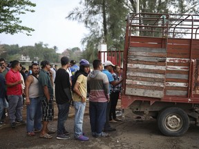 Central American migrants traveling with the annual "Stations of the Cross" caravan wait in line to receive food at the sports club where they have been camping out in Matias Romero, Oaxaca State, Mexico, Thursday, April 5, 2018. Migrants in a caravan that drew criticism from U.S. President Donald Trump began packing up their meager possessions and boarding buses to the Mexican capital and the nearby city of Puebla on Thursday.