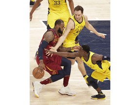 Cleveland Cavaliers forward LeBron James (23) is defended by Indiana Pacers guard Darren Collison (2) and forward Bojan Bogdanovic (44) during the first half of Game 4 of an NBA basketball first-round playoff series in Indianapolis, Sunday, April 22, 2018.